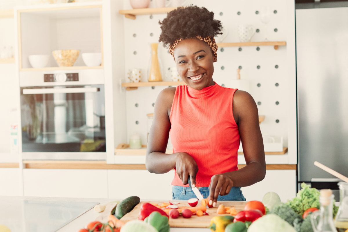 femme africaine coupant des légumes